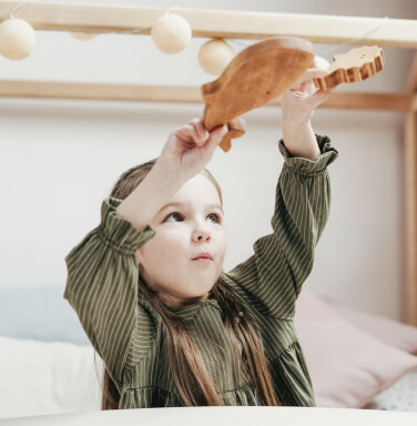 Toddler playing with wooden toy animals